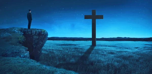 Man standing on the top of the cliff looking to the cross — Stock Photo, Image