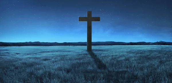 Христианский крест посреди луга — стоковое фото