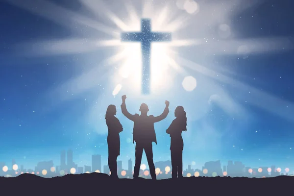 Silhueta de três pessoas olhando cruz cristã no céu — Fotografia de Stock