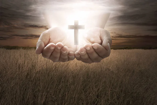 Mão humana segurar cruz cristã — Fotografia de Stock