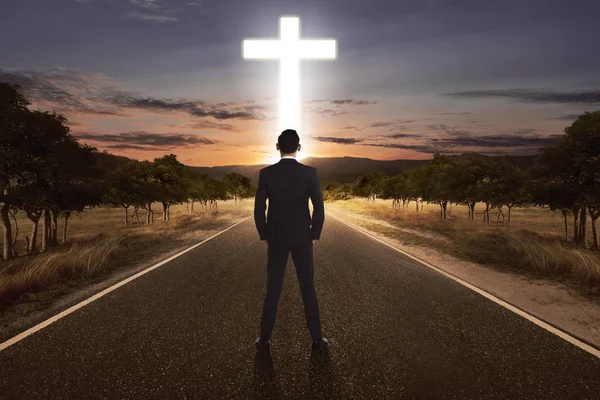 Vue arrière de l'homme debout dans la rue avec une croix lumineuse — Photo