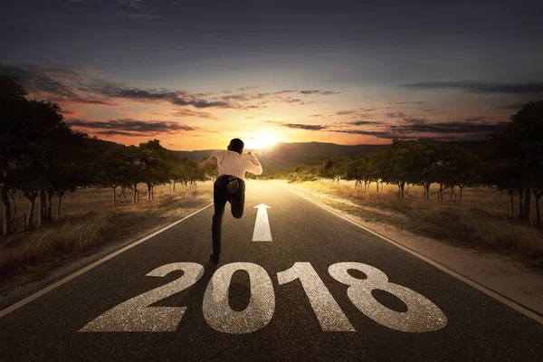 Hombre de negocios corriendo en la calle con el número 2018 —  Fotos de Stock