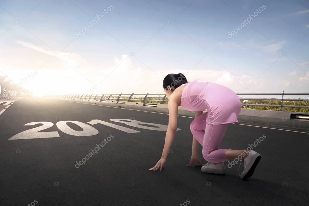 woman ready to running with 2018 number 