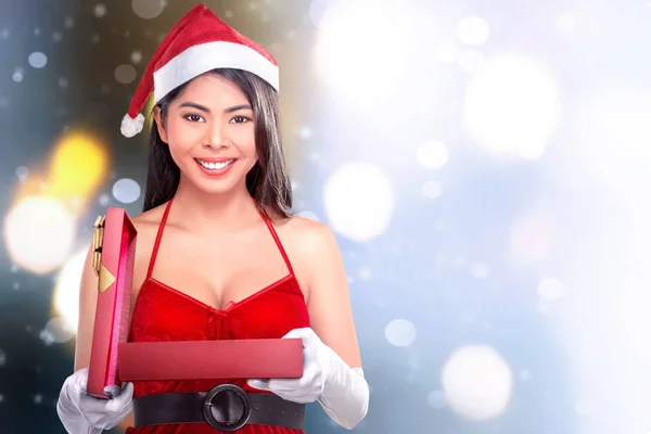 Gyönyörű ázsiai lány megnyitása karácsonyi ajándék Mikulás kalap — Stock Fotó