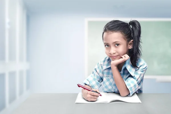 Fröhliche Asiatische Mädchen Mit Stift Und Buch Auf Dem Klassenzimmer — Stockfoto
