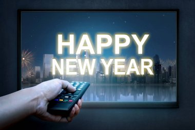 Tv ekranında TV uzaktan kumanda ile yeni yıl işaret tutan el. Mutlu yeni yıl 2018