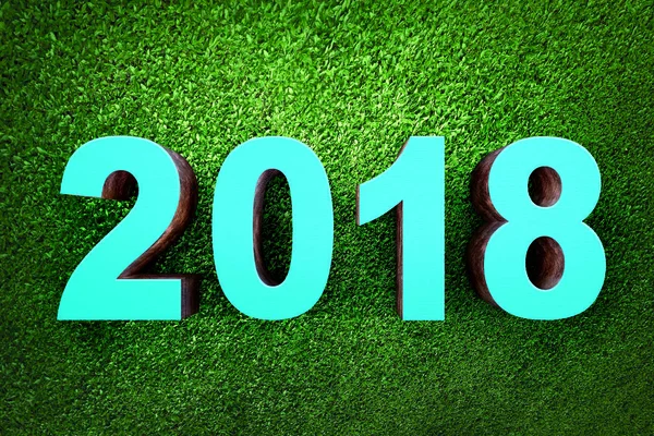 Blue numbers 2018 from wood on grass background. Happy New Year 2018