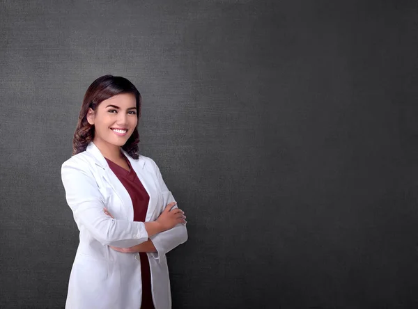 黒板を背景に立っている組んだ腕を持つ若いアジア ビジネス女性 — ストック写真