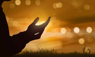 İnsan eli açık avuç günbatımı arka plan Tanrı'ya dua siluetleri