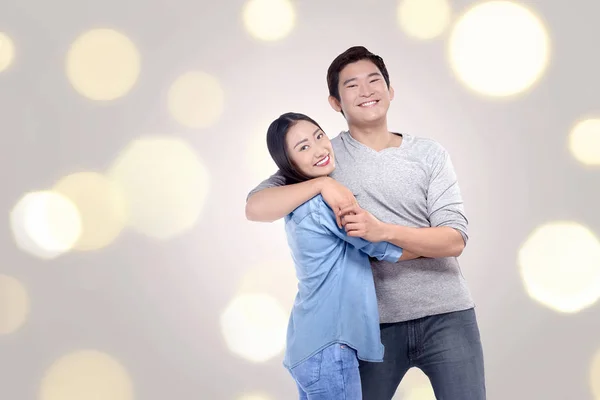 Happy asian couple hugging each other on blur background
