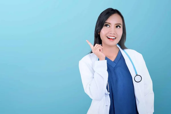 Young asian doctor with stethoscope pointing finger up — Stock Photo, Image