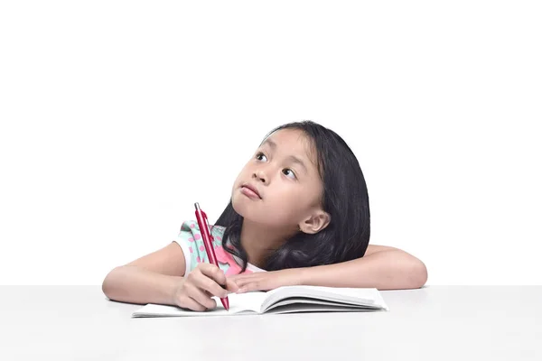 Porträt eines kleinen asiatischen Mädchens mit Stift schreiben auf dem Notizbuch — Stockfoto