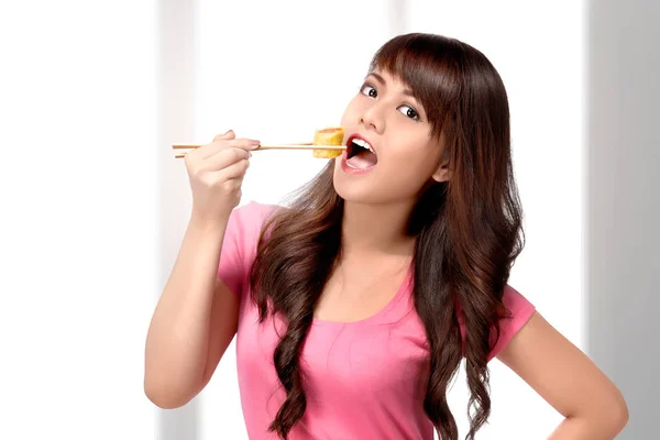 Krásná Asijská Žena Jíst Sushi Při Používání Hůlky Doma — Stock fotografie