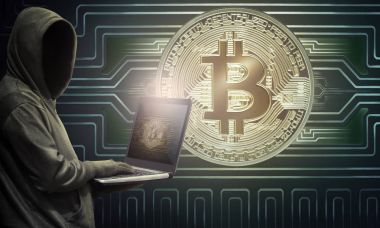 Bitcoin simgesi olan dizüstü bilgisayar ekranı, finans ve teknoloji kavramı üzerinde tutarak hacker