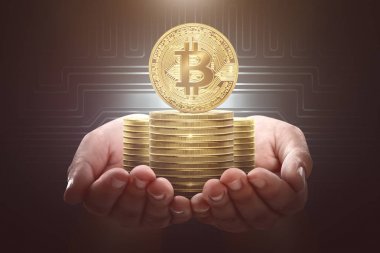 devre kartı arka plan ile altın bitcoins yığını tutan erkek el