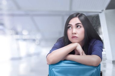 Asya seyahat kadın bavul Havaalanı terminal uçakta bekliyor ile sıkılmış