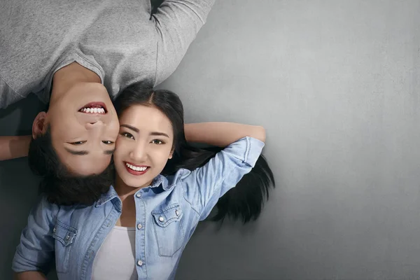 Lächelndes Asiatisches Verliebtes Paar Legt Sich Auf Grauen Hintergrund — Stockfoto
