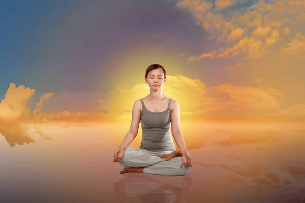 asian woman doing yoga with sunset background