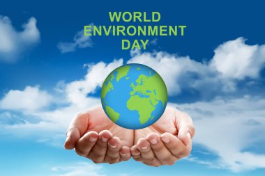 Küre mavi gökyüzü arka plan üzerinde tutan eller