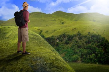 Asya backpacker tepe tepe üzerinde duran arka görünümü