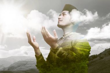 Religious asian muslim praying to god with landscape on  background