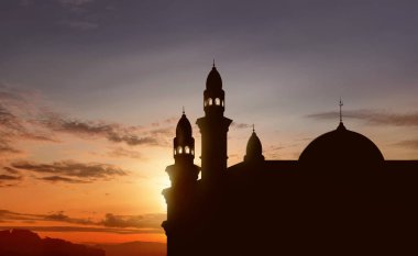 Gün batımında yüksek minare ile büyük Camii silüeti