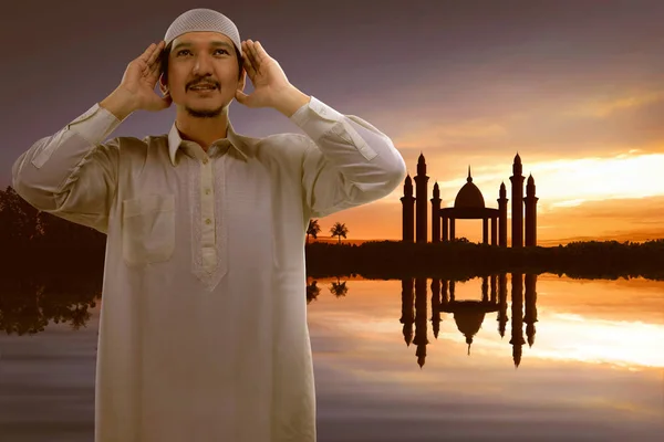 年轻的亚洲穆斯林男子举起手和日落背景祈祷 — 图库照片
