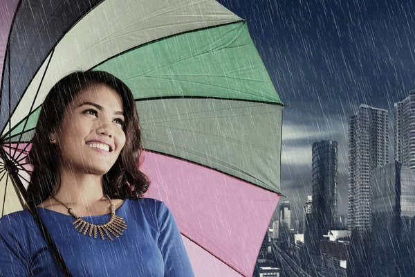 Pretty asian woman with umbrella at rain on the city