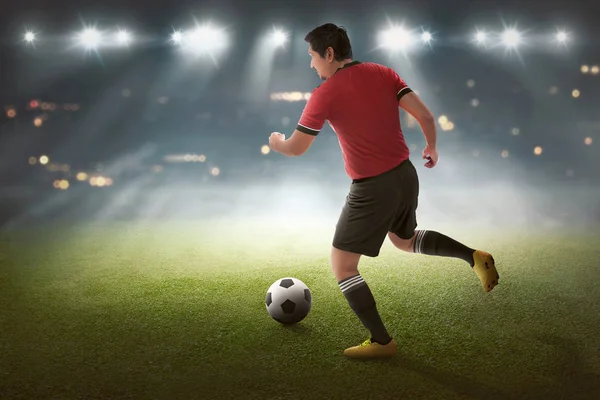 スタジアムでボールを持つ若いアジア サッカー プレイヤー — ストック写真