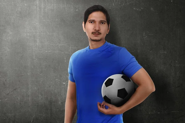Attraktiva Asiatisk Fotbollsspelare Håller Bollen Över Mörka Vägg Bakgrund — Stockfoto