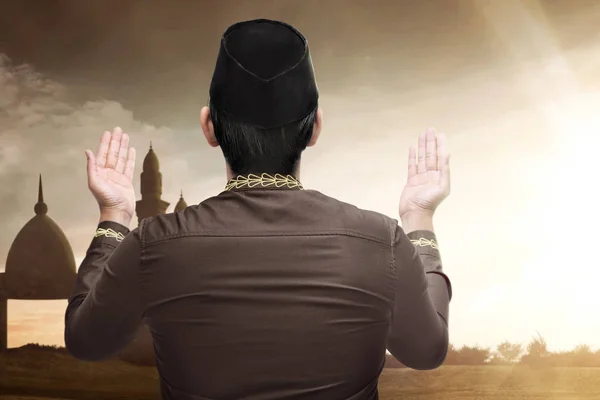 亚洲穆斯林男子与帽子祈祷上帝与阳光背景的背面视图 — 图库照片