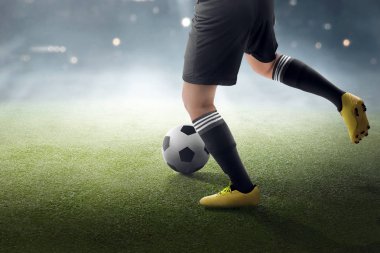 Çim sahada topu tekmeleme için çalışıyor futbol oyuncusu