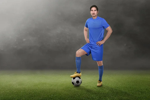 緑の野に腰に手の若いアジア サッカー選手 — ストック写真
