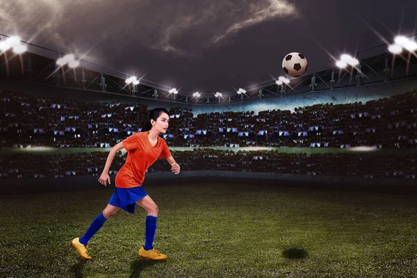 若いアジア女性フットボール選手がスタジアム フィールド上にボールを蹴りをたいです — ストック写真