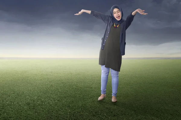 緑の野原に立ってうれしそうなアジアのイスラム教徒の女性 — ストック写真