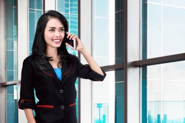 Genç Asyalı işkadını Office smartphone cep telefonu ile konuşmak