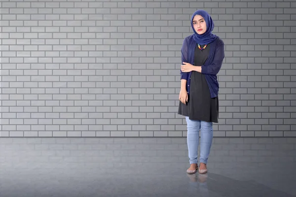 レンガの壁に立っているアジアのイスラム教徒の女性 — ストック写真