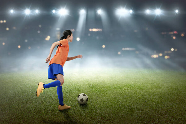 Young soccer player kicking ball