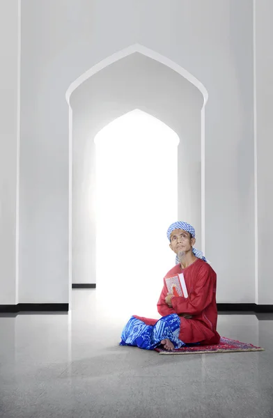 亚洲穆斯林男子在清真寺举行可兰经的侧面看法 — 图库照片