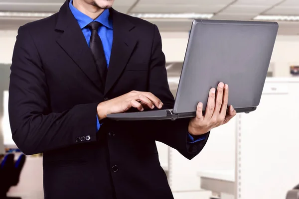 Biznesmen Posiadania Laptopa Podczas Pisania Urząd — Zdjęcie stockowe