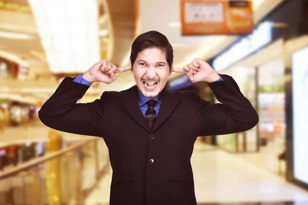 Mladá Asiatka podnikatel pokrývající uši svým prstem — Stock fotografie