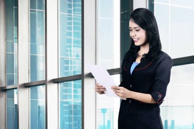 Başarılı Asya iş kadını ofiste onun elinde belge ile