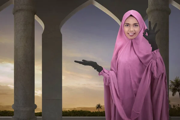 年轻的亚洲女性穆斯林显示空的区域为 Copyspace 与日落背景 — 图库照片