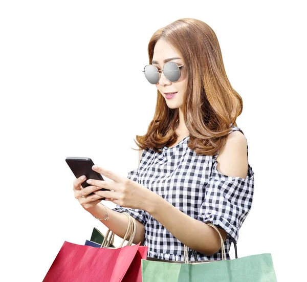Mujer asiática con gafas de sol usando el teléfono móvil mientras lleva —  Fotos de Stock