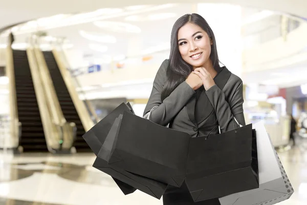 Aziatische zakenvrouw dragen boodschappentassen in het winkelcentrum — Stockfoto