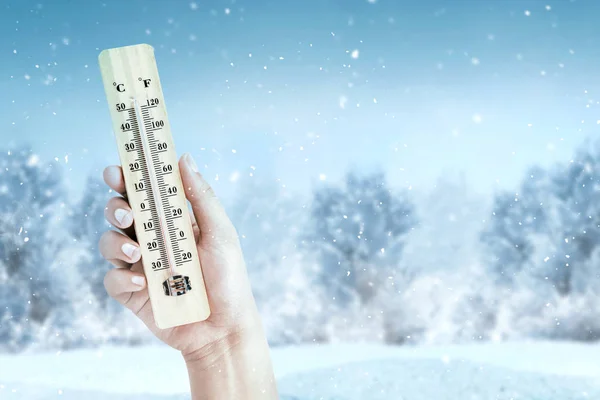 Χέρι κρατώντας ξύλινο θερμόμετρο με τη χαμηλή θερμοκρασία σε wint — Φωτογραφία Αρχείου