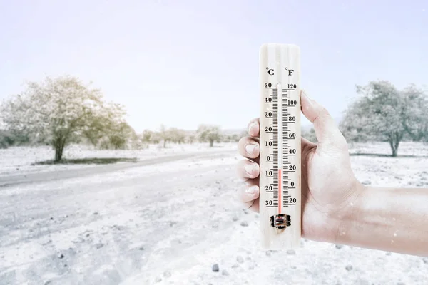 Termômetro de mão medindo a temperatura ao ar livre com — Fotografia de Stock