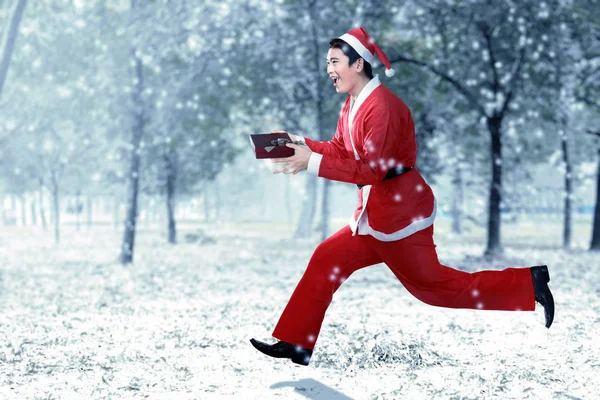 Азіатський чоловік в Санта-костюм працює при проведенні Подарункова коробка — стокове фото
