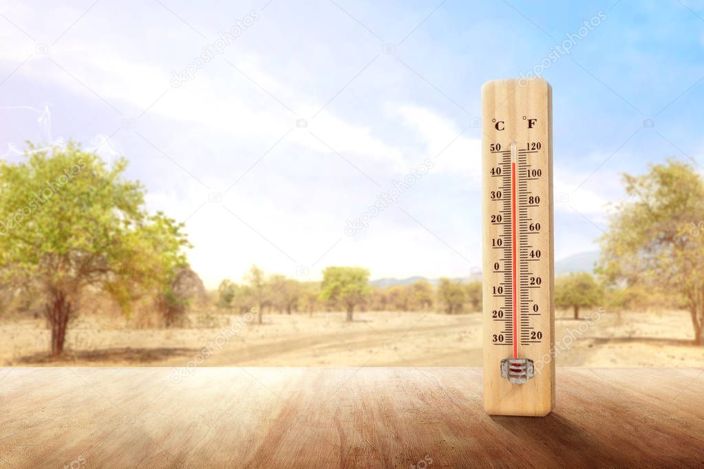 The thermometer on a wooden table measuring the temperature outd