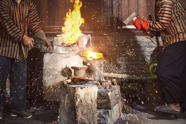 铁匠用铁锤锻造熔融的金属做衬垫 — 图库照片